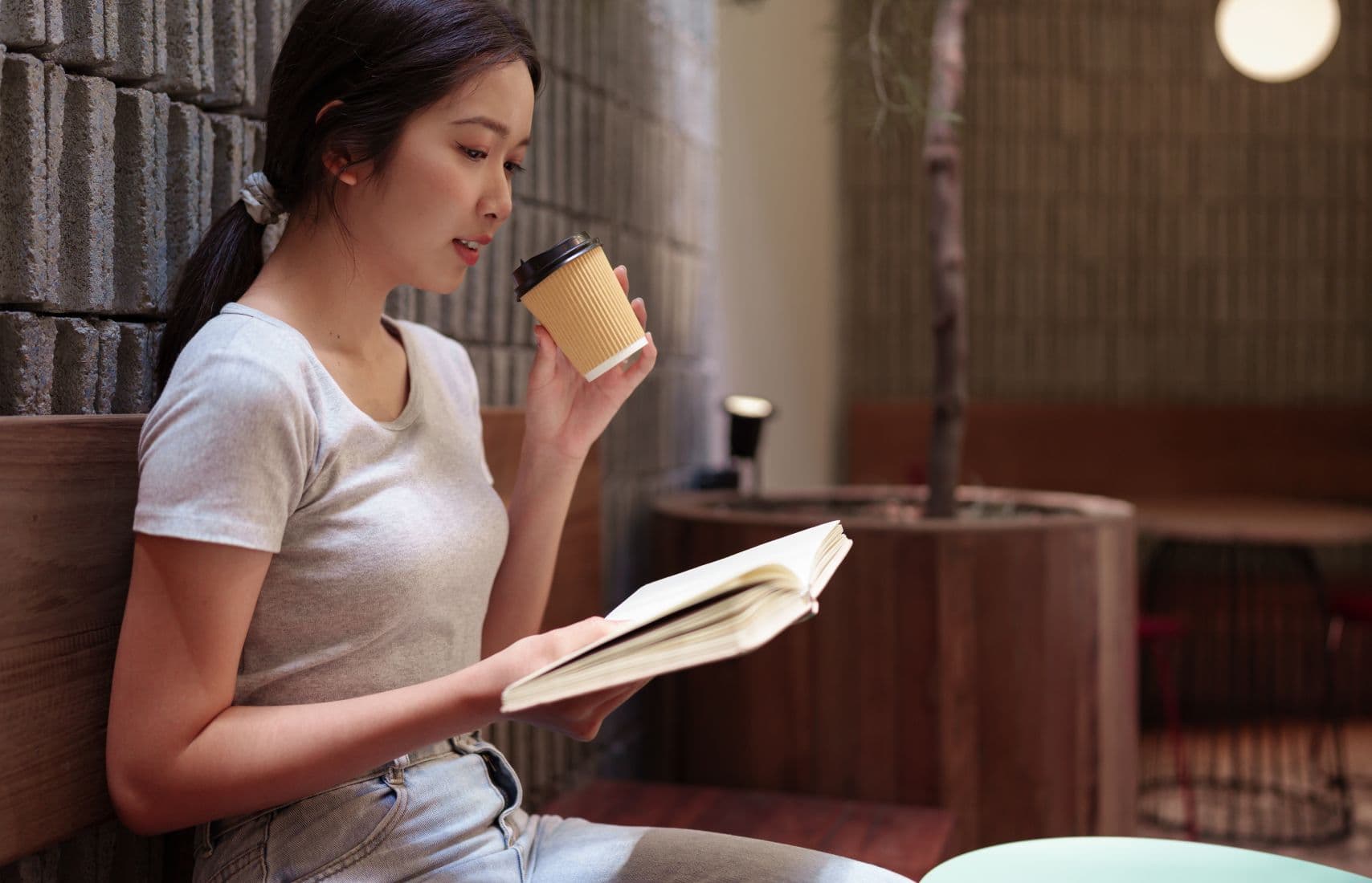 A woman reading a book in a cafe.